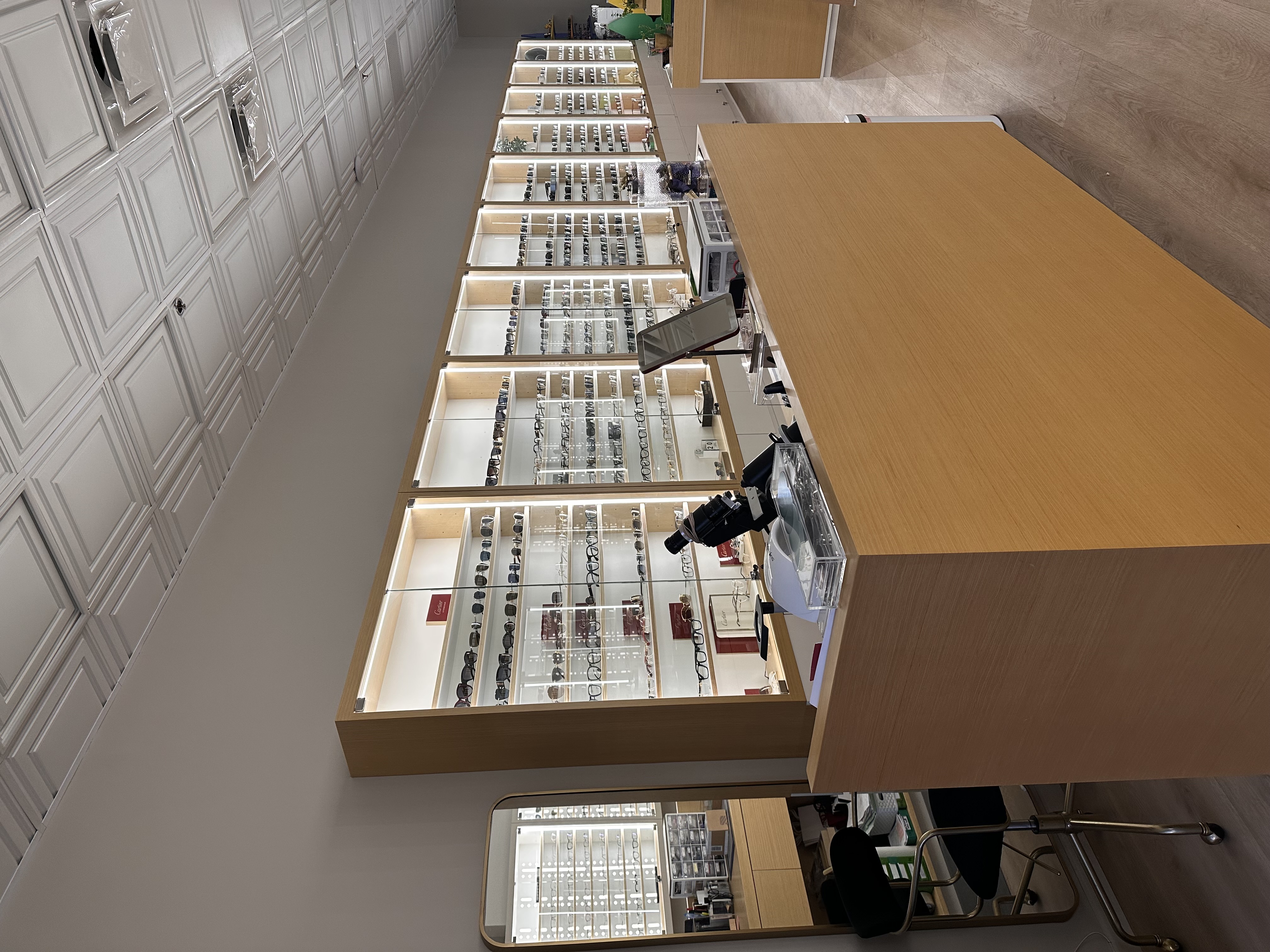 Eye Atelier luxury optical boutique interior in Old Bridge, NJ — designer eyewear displays along a backlit wall